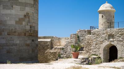 A stone tower with a potted plant.