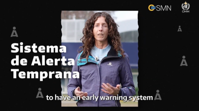 Person presenting about an early warning system on a screen with spanish text "sistema de alerta temprana".